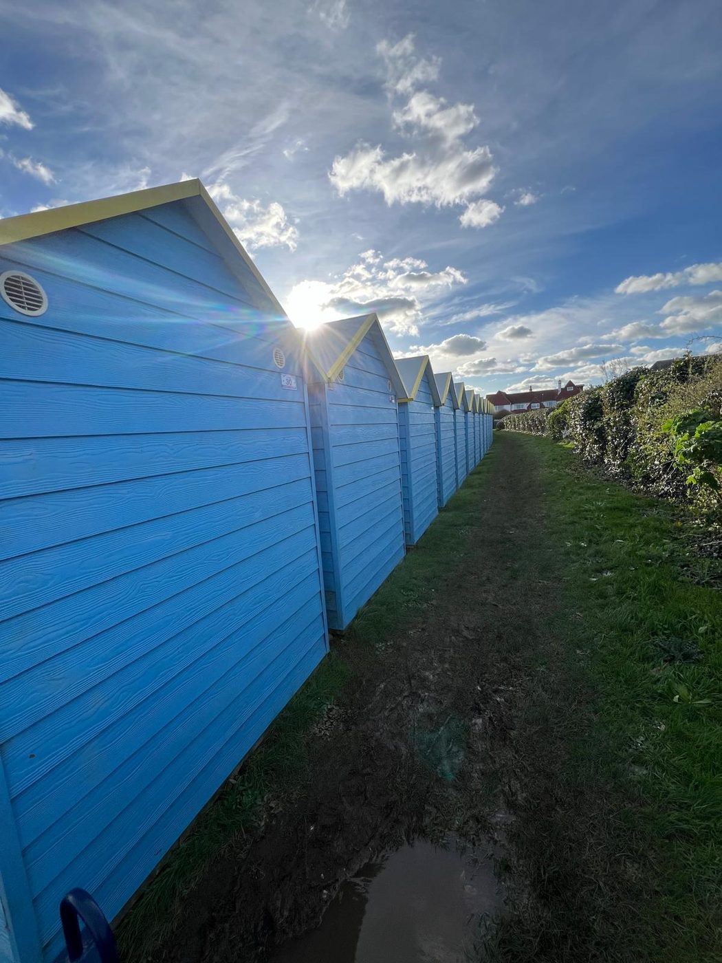 A row of blue beach huts cleaned along the West Sussex coast