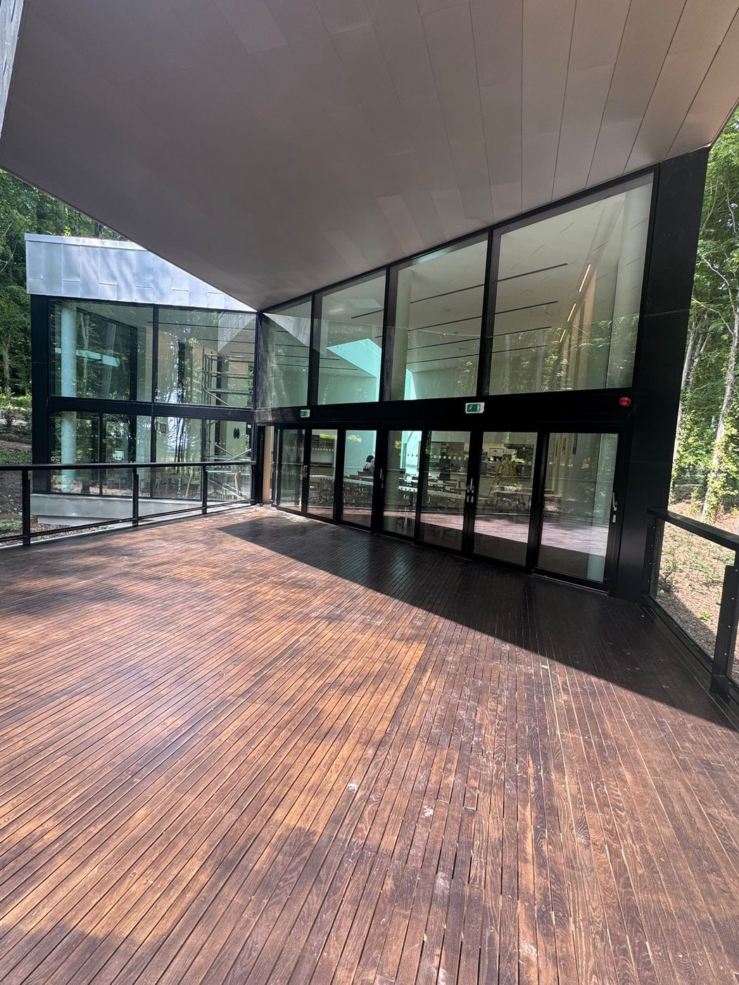 The cleaned timber deck and glazing of a contemporary building in West Sussex