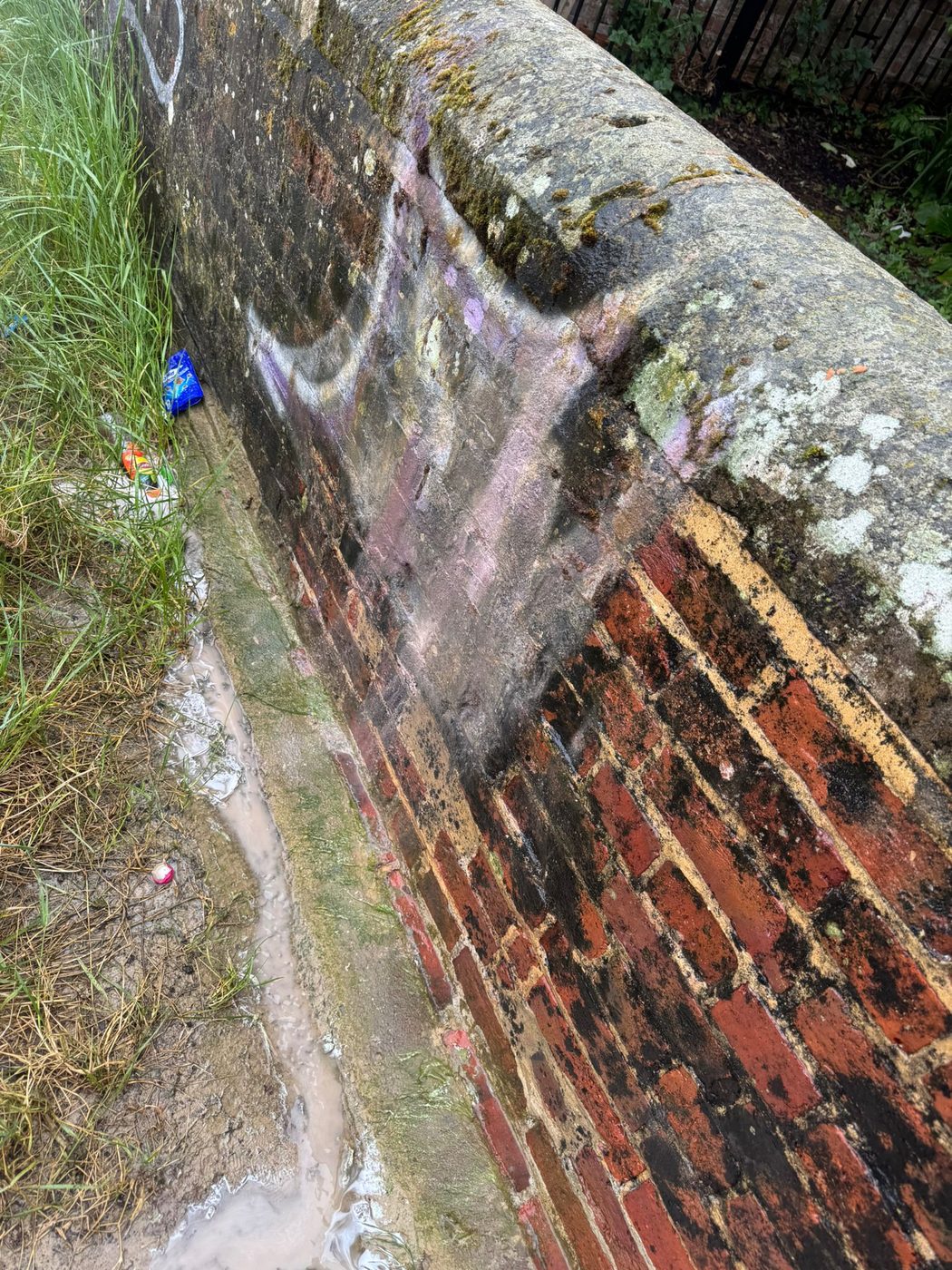 The same brick wall after graffiti removal in West Sussex
