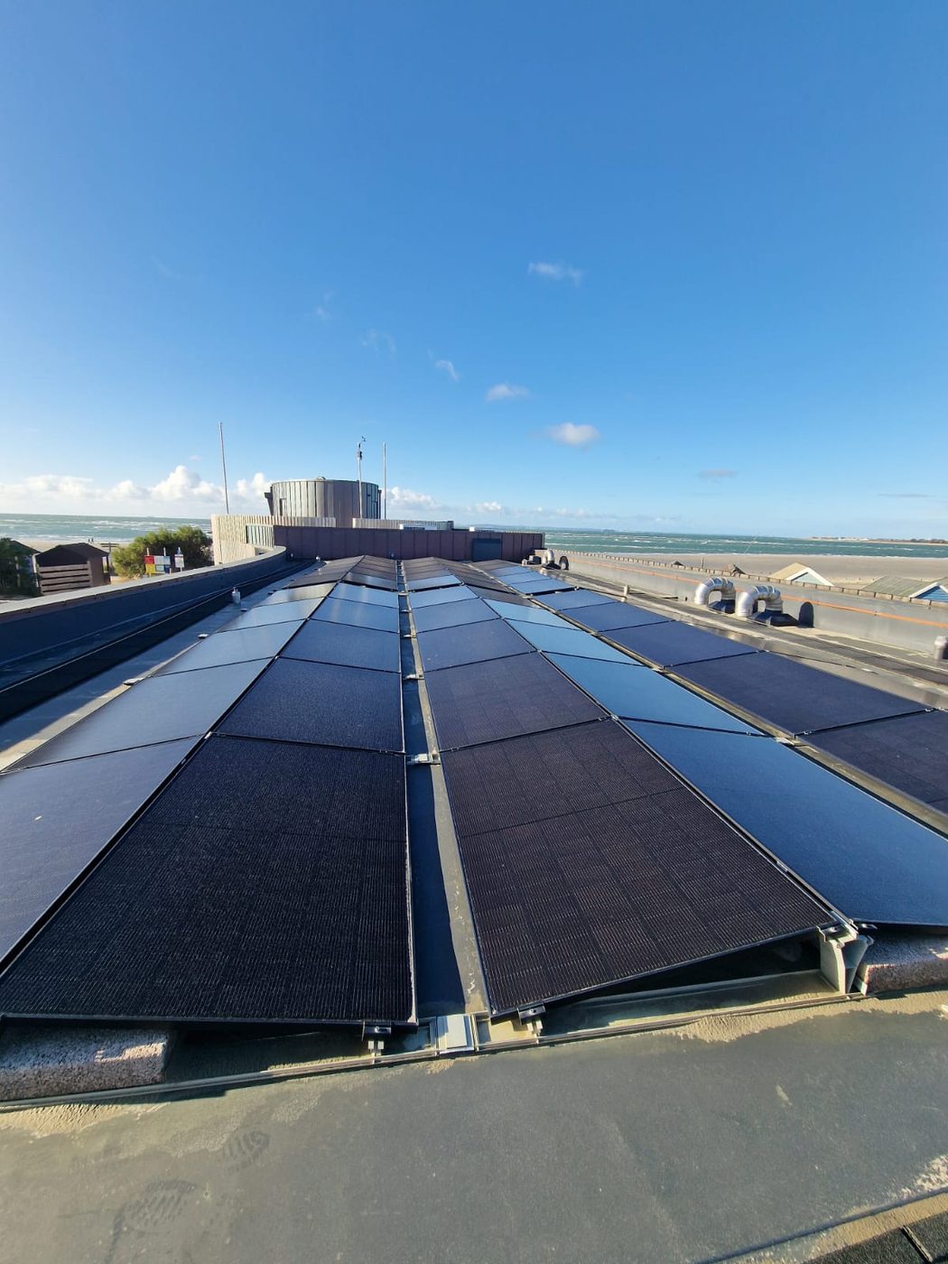 A large commercial rooftop solar array cleaned beside the coast in West Sussex