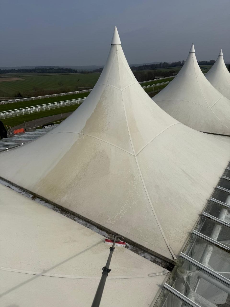 Soft washing the white tensile fabric canopy roofs at Goodwood Racecourse grandstand