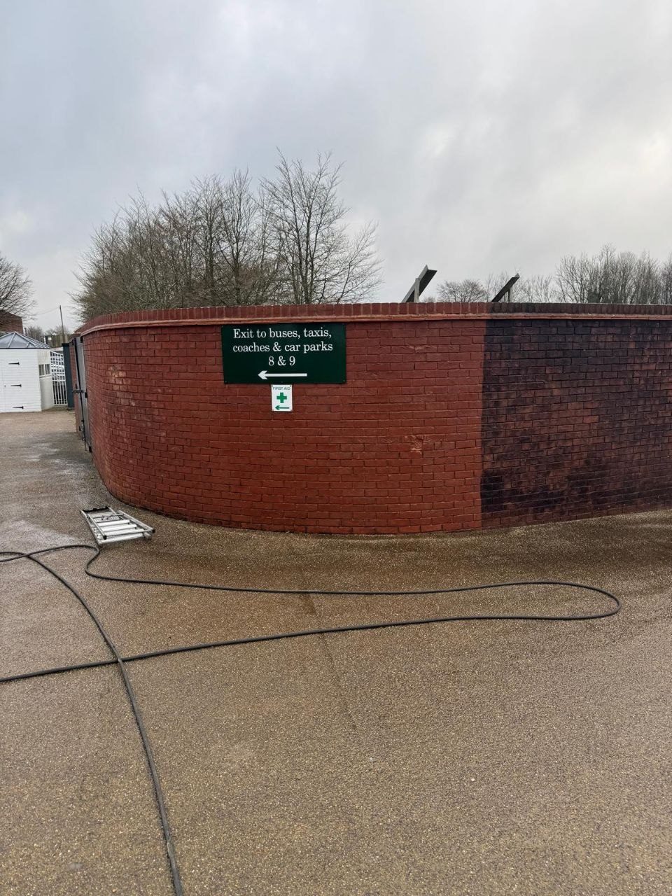 A curved brick courtyard wall and surround cleaned in West Sussex