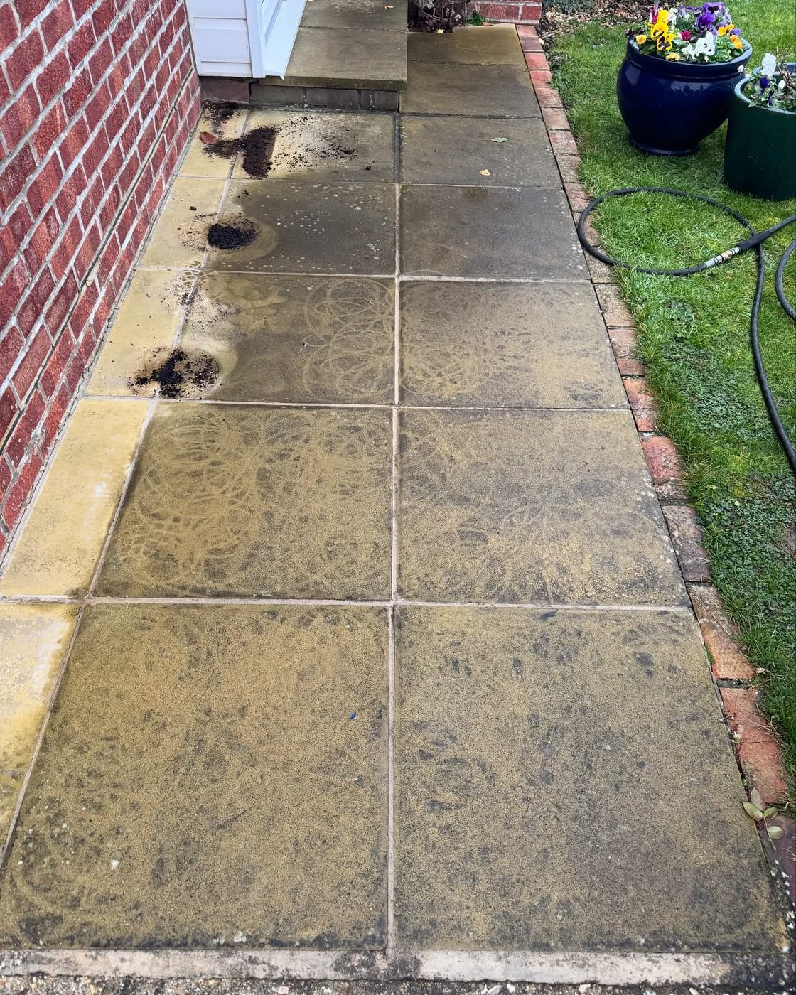 A block-paved driveway part-way through cleaning, showing the difference