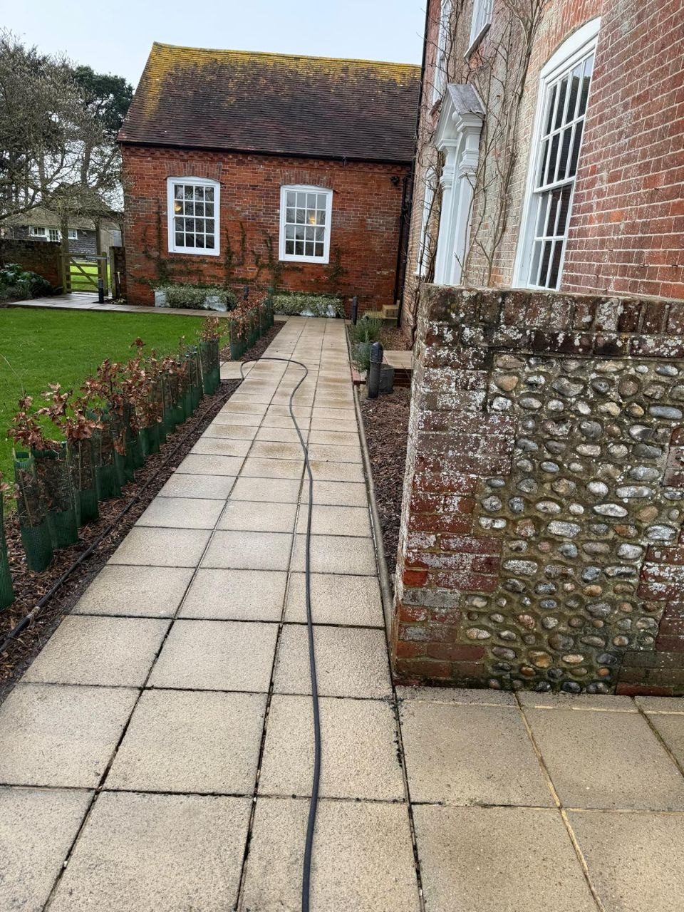 Path cleaning at a flint-walled period property in West Sussex