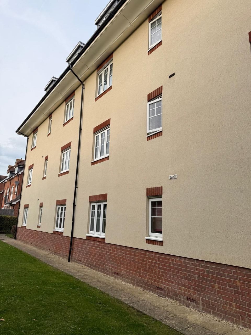 The same apartment block render cleaned back to colour after soft washing