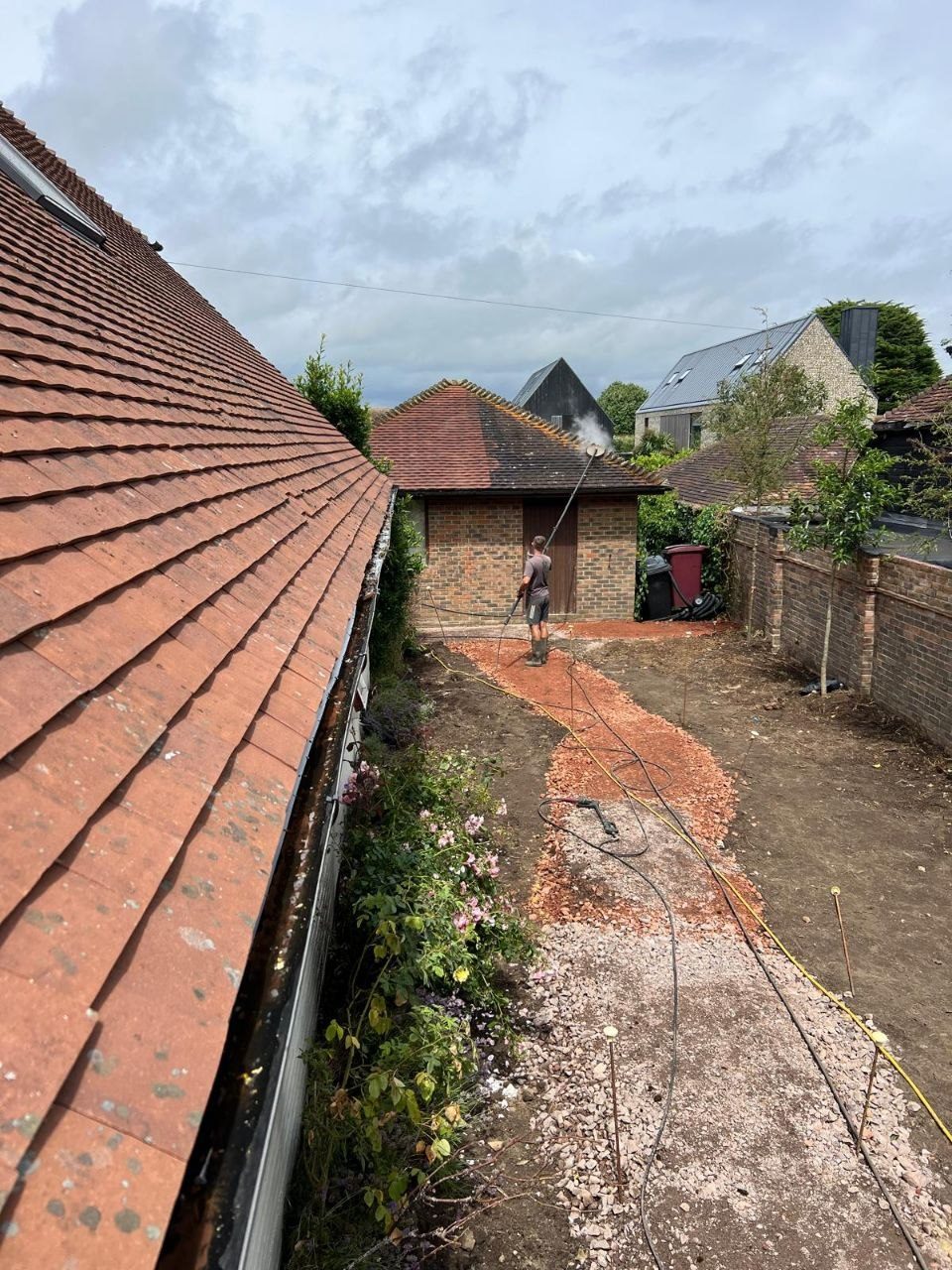 A tiled roof covered in moss before treatment in West Sussex