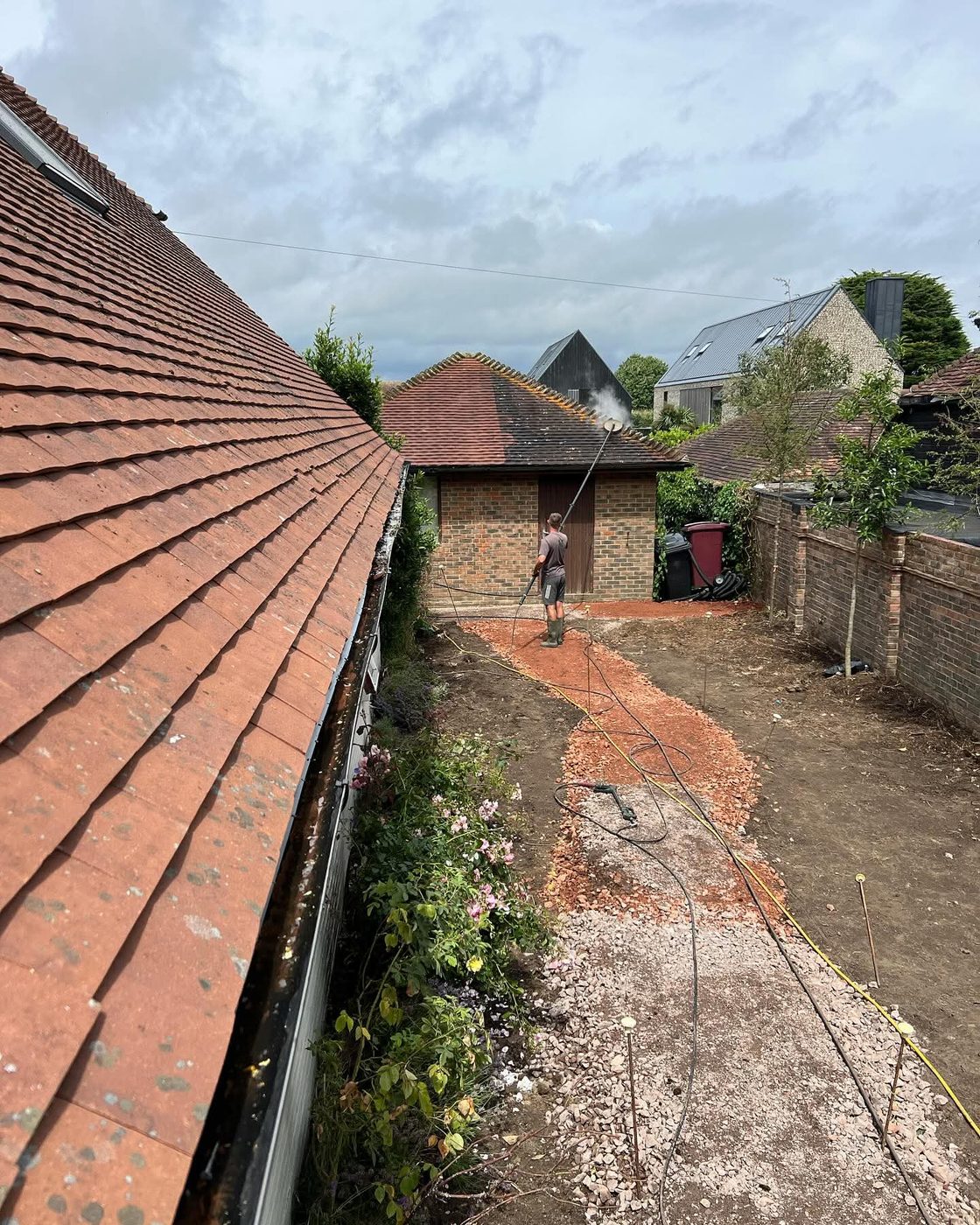 Moss cleared from ridge tiles during a roof clean