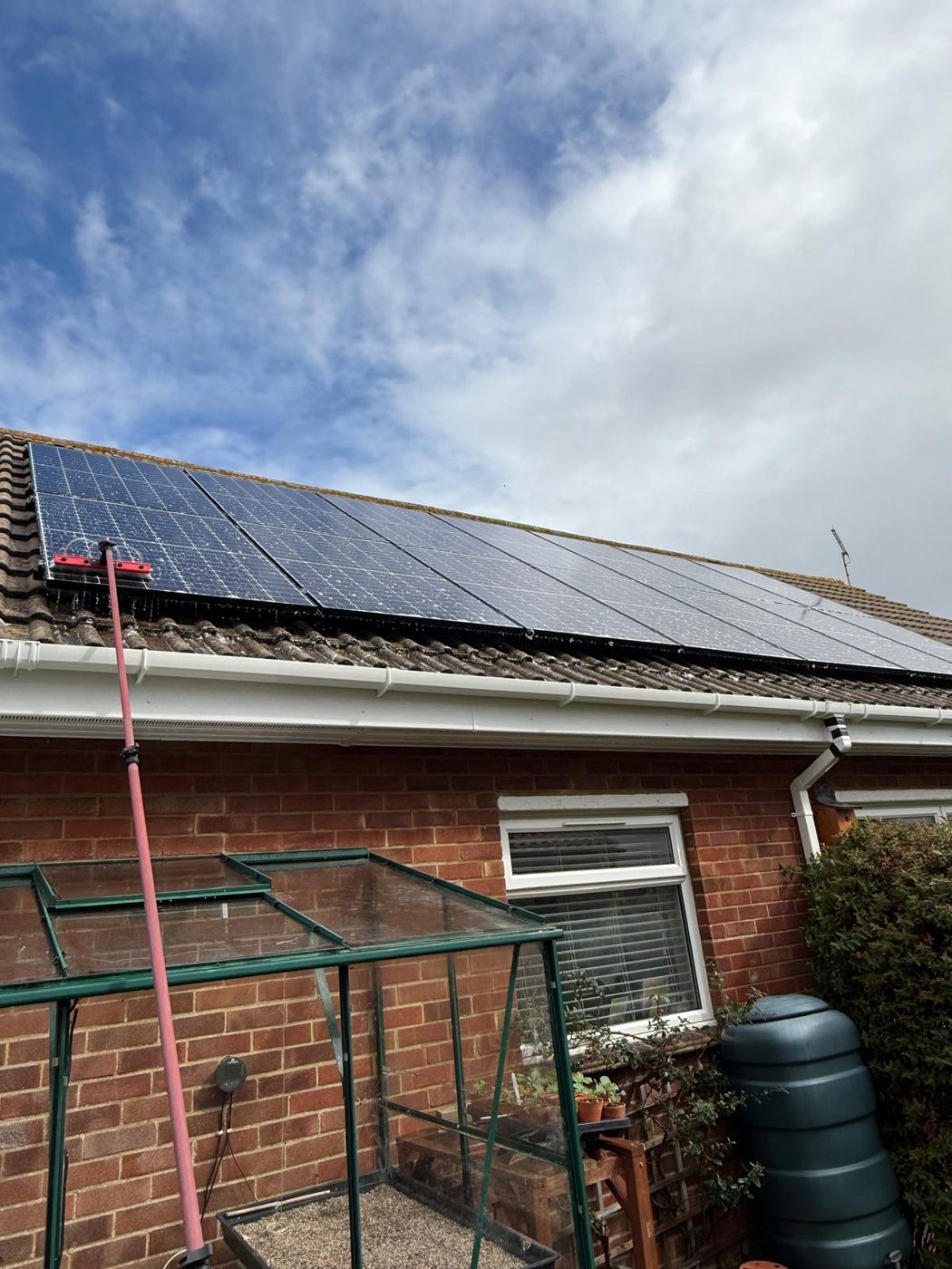 Solar panels cleaned on a domestic brick house roof in West Sussex