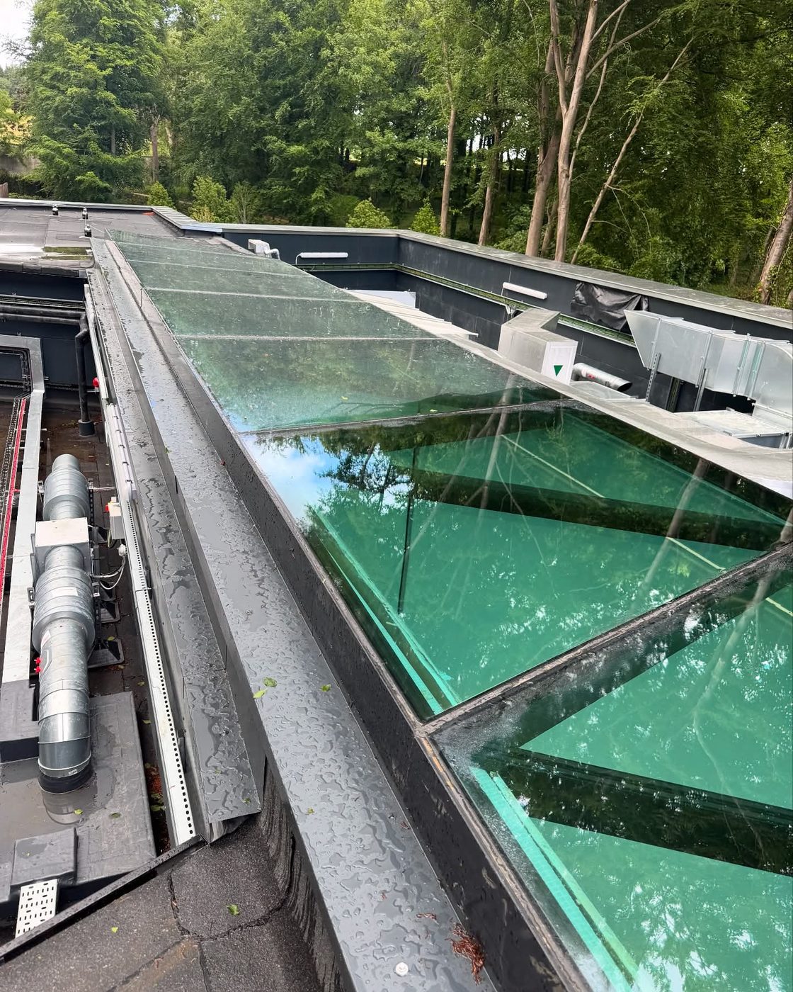 A long glass rooflight cleaned at height above a building's plant deck in West Sussex