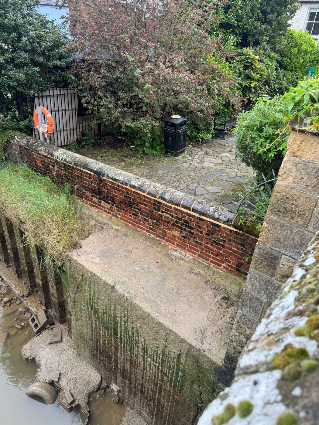 A mossy walled courtyard and brickwork before cleaning